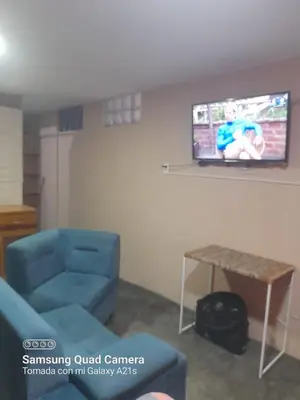 a living room with a blue couch and a tv at Your home in the city awaits in Lima