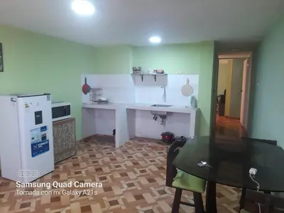 a kitchen with a sink and a table and a refrigerator at Your home in the city awaits in Lima
