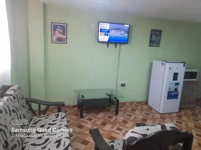 a living room with a couch and a refrigerator at Your home in the city awaits in Lima