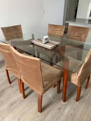 a glass dining table with four chairs and a glass table with a plate at Departamento céntrico rodeado de áreas verdes in Lima