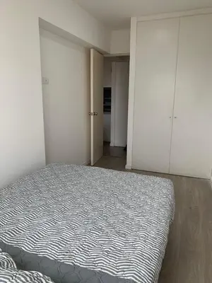 a bedroom with a bed and white cabinets at Departamento céntrico rodeado de áreas verdes in Lima