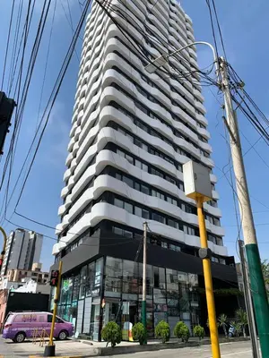 a tall building with a purple van in front of it at Departamento céntrico rodeado de áreas verdes in Lima