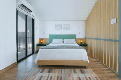 a bedroom with a large bed and a balcony at Tiny House con Piscina Privada, AC and Starlink in Paracas