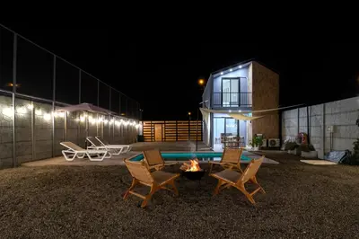 a house with a fire pit in the yard at night at Tiny House con Piscina Privada, AC and Starlink in Paracas