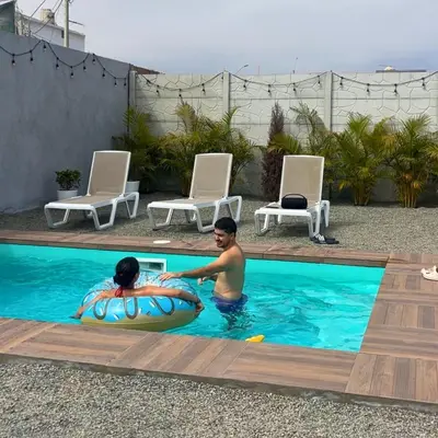 a man and a child in a swimming pool at Tiny House con Piscina Privada, Jacuzzi, Parrilla y Starlink in Punta Negra