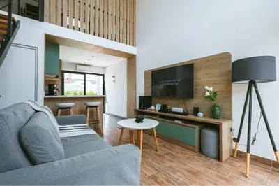 a living room with a couch and a tv at Tiny House con Piscina Privada, Jacuzzi, Parrilla y Starlink in Punta Negra