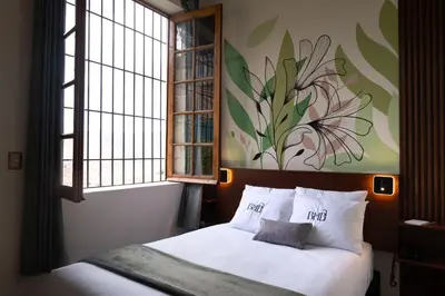 a bedroom with a bed with a flower painting on the wall at Bosco Hotel Boutique in Cusco