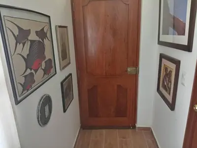 a wooden door in a hallway with pictures on the wall at Mi lagartitas Bungalow in Oxapampa
