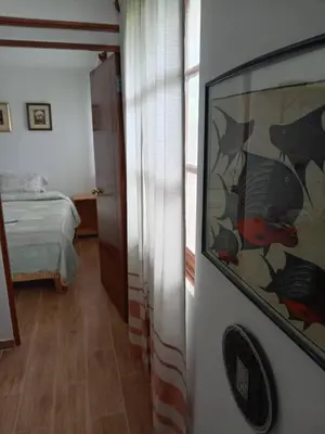 a bedroom with a bed and a large painting on the wall at Mi lagartitas Bungalow in Oxapampa