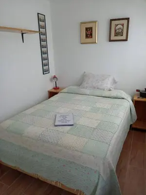 a bedroom with a bed with a sign on it at Mi lagartitas Bungalow in Oxapampa