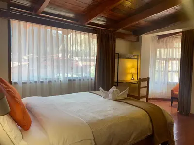 a bedroom with a large bed and a large window at Juliet's House in Ollantaytambo