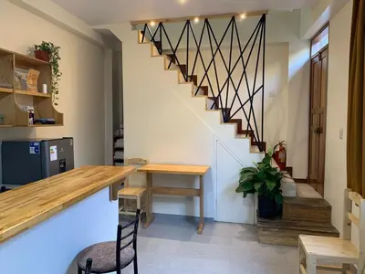 a dining room with a table and a staircase at Juliet's House in Ollantaytambo