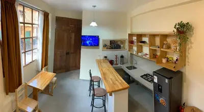 a kitchen with a counter and a table and chairs at Juliet's House in Ollantaytambo