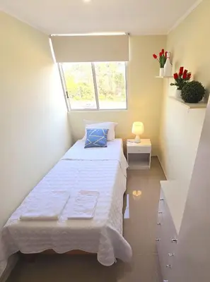 a small bedroom with a bed and a window at Apartamento Premium frente a Universidad San Marcos para 4 pers en lima in Lima