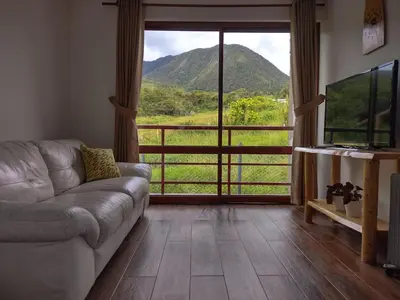a living room with a couch and a view of a mountain at Sweet Home Oxapampa in Oxapampa