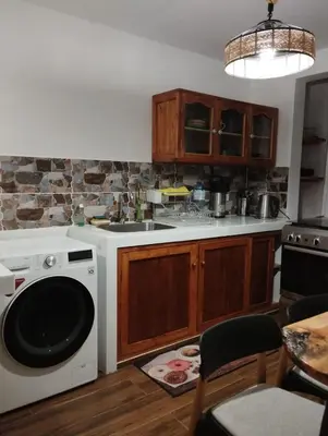 a kitchen with a white dishwasher and a stove at Sweet Home Oxapampa in Oxapampa