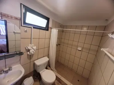 a bathroom with a toilet and a sink and a window at HOTEL HUAYNAPATA Pardo in Cusco