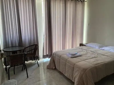 a bedroom with a bed and a table and chairs at Mablia Suite in Ica