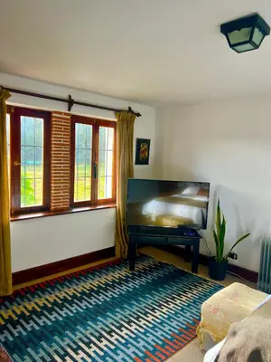 a bedroom with a bed and windows and a rug at Inka Tambo Hacienda in Cusco
