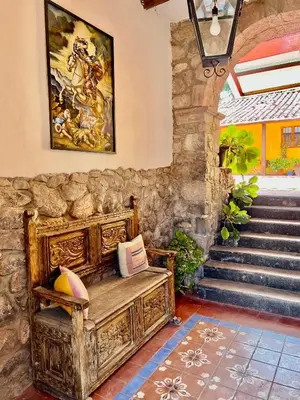 a room with a wooden bench and a painting on the wall at Inka Tambo Hacienda in Cusco