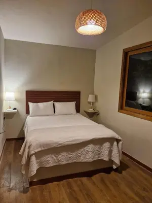 a bedroom with a large bed and a chandelier at Tornameza Casa de Campo in Torna Mesa