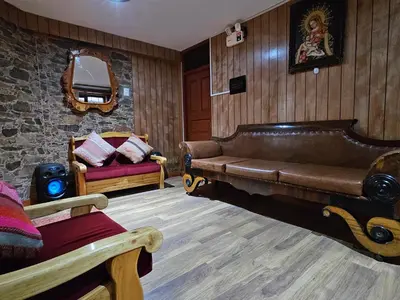 a living room with a leather couch and a chair at SAMAY WASI b&b in Cusco