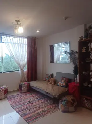 a living room with a couch and a window at Apartment 12 min from airport in Lima