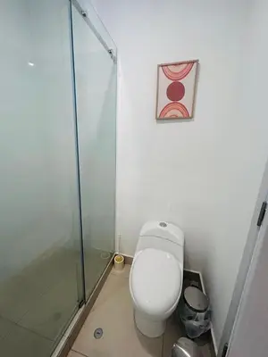 a bathroom with a toilet and a glass shower at departamento nuevo con espectacular vista entre surco y Miraflores in Lima