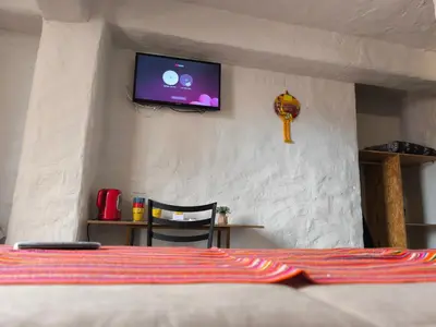 a bedroom with a bed with a tv on the wall at Waalay Hotel in Huancayo