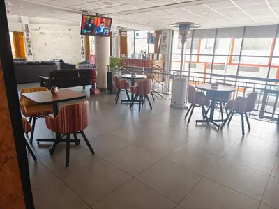 a dining room with tables and chairs and a tv at Waalay Hotel in Huancayo