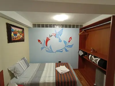 a bedroom with a bed with a painting on the wall at The Culinary Stay and Taste in Cusco