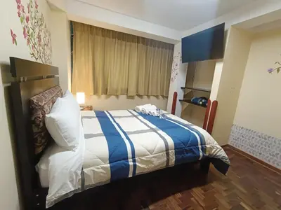 a bedroom with a bed with a blue and white blanket at The Culinary Stay and Taste in Cusco