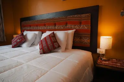 a bedroom with a large white bed with red pillows at The Culinary Stay and Taste in Cusco