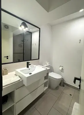 a bathroom with a sink and a toilet and a mirror at San Isidro 1 Bedroom RN in Lima