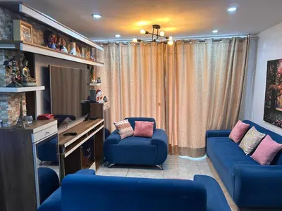 a room with two blue chairs and a desk at Departamento Palmeras in Lima