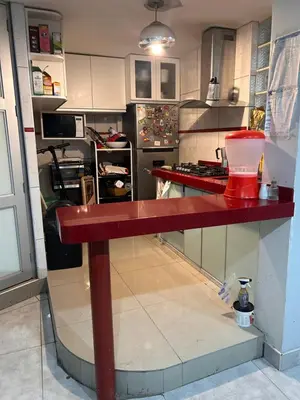 a kitchen with a red counter in the middle at Departamento Palmeras in Lima