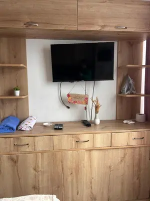 a large wooden entertainment center with a tv on a wall at Departamento Palmeras in Lima