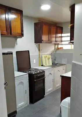 a kitchen with white cabinets and a black stove at La casona cusco in Cusco