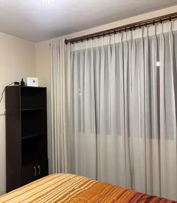a bedroom with a bed and a window with curtains at La casona cusco in Cusco