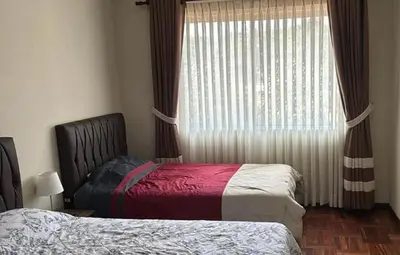 a bedroom with two beds and a window with curtains at Departamento centrico cusco in Cusco