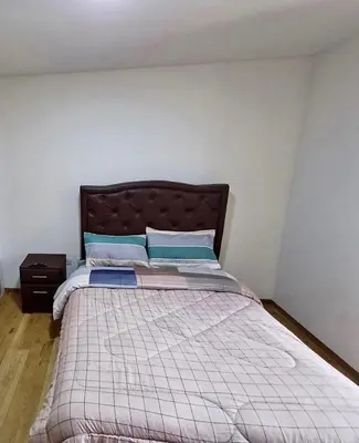 a bedroom with a bed with a brown headboard at Apartment in cusco center in Cusco