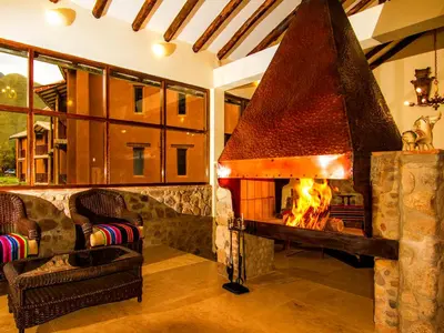a fireplace in a living room with a fire place at Lizzy Wasi Urubamba in Urubamba