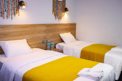 a room with two beds with yellow and white at Hotel Litan Machu Picchu in Machu Picchu