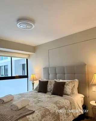 a bedroom with a large bed with a large window at Luxurious brand new apartment in Lima
