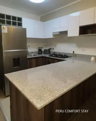a kitchen with a counter top and a refrigerator at Luxurious brand new apartment in Lima