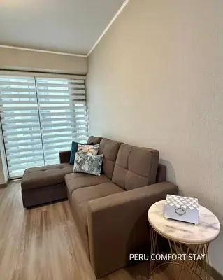 a living room with a brown couch and a table at Luxurious brand new apartment in Lima