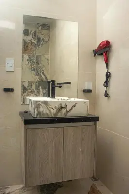 a bathroom sink with a mirror and a red phone at Luxurious Apt with Rooftop, BBQ, and Beach nearby in Punta Hermosa