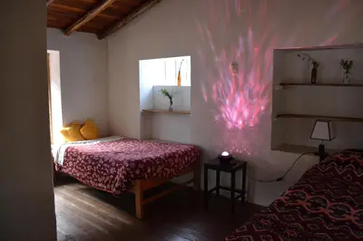 a bedroom with a bed and a window with a pink wall at Cabaña rodeada de naturaleza en Ollantaytambo in Ollantaytambo