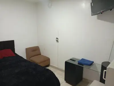a bedroom with a bed and a chair at Lima Colibrí habitaciones in Lima