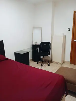 a bedroom with a bed and a desk and a chair at Lima Colibrí habitaciones in Lima